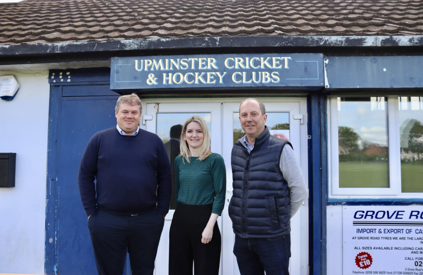 Julia Lopez MP with two people from Upminster Cricket Club outside the pavilion.
