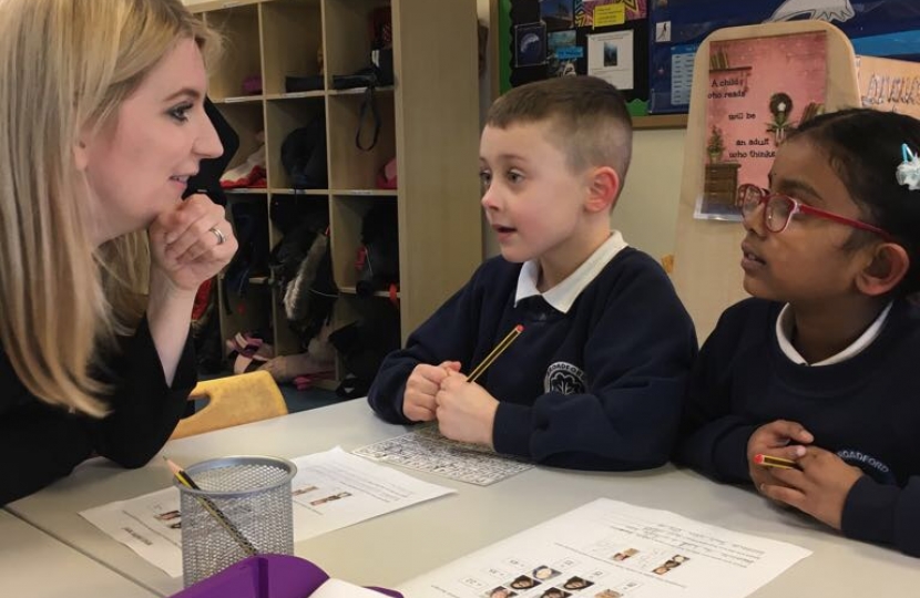 Julia sat on a table with pupils chatting to them at Broadford Primary.