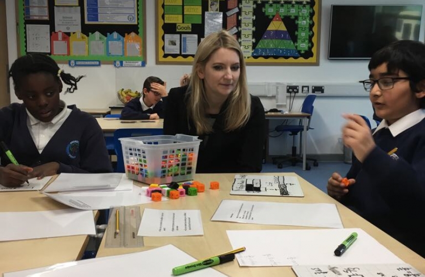 Julia sat on a table with pupils chatting to them at Broadford Primary.