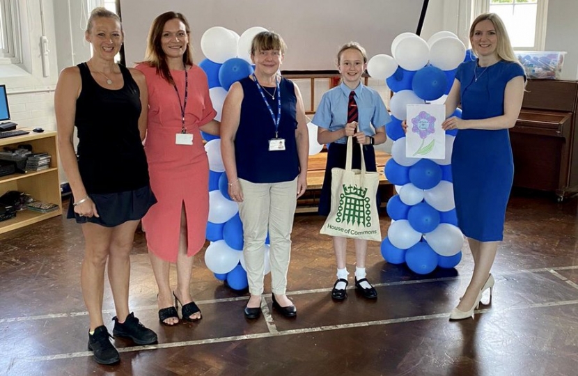 Julia standing with a pupil as they are presented with an award at Langtons.