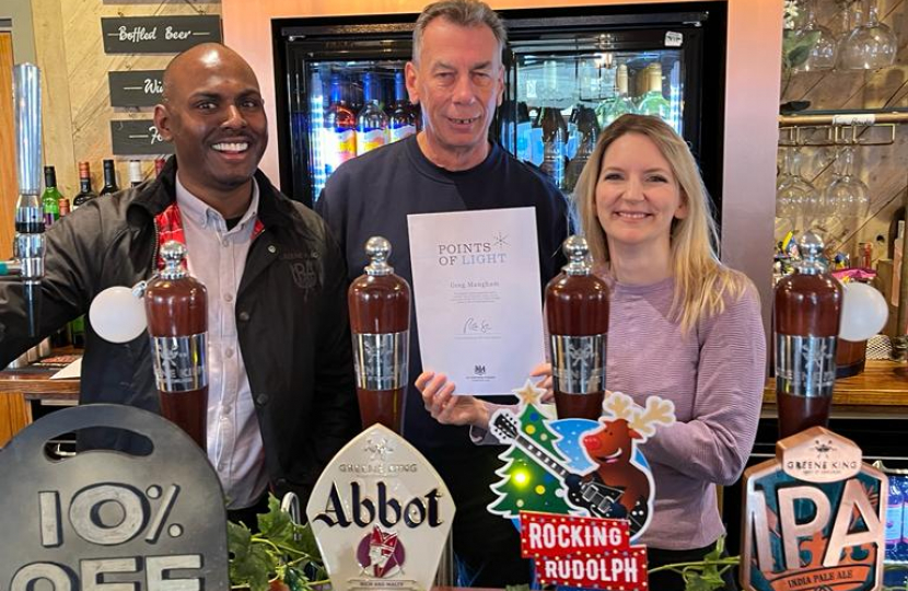 Julia Lopez MP with Gavin Chinasamy, Manager of The Windmill Pub, presents Greg Mangham with his Points of Light Award