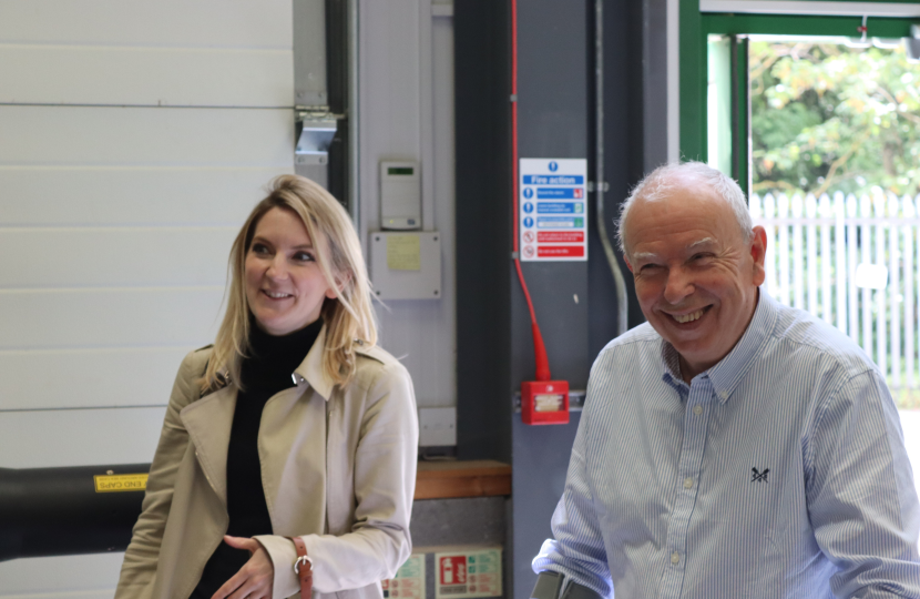 Julia and Stuart both smiling for a photograph in the workshop.