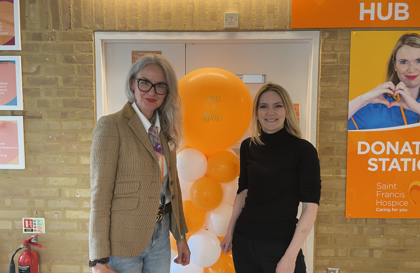 Photo of Julia and Grazina in front of an orange balloon to celebrate 40 years of the hospice during Julia's visit.