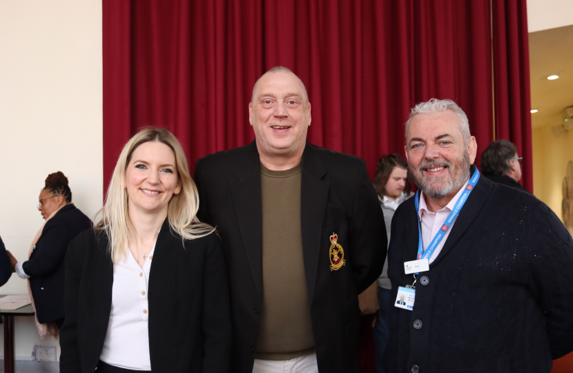 Julia posing for a photo with the Armed Forces Champion for the area and someone he helped into work.