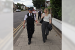 Julia walking down the street with a police officer.