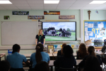 Photo of Julia speaking to pupils at Sacred Heart during her May visit last year. The photo is taken from the back of the classroom.