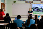 Photo of Julia speaking to pupils at Sacred Heart during her May visit last year. The photo is taken from the back of the classroom.