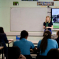 Photo of Julia speaking to pupils at Sacred Heart during her May visit last year. The photo is taken from the back of the classroom.